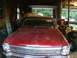 1966 Chevrolet Nova - A red 1966 Chevrolet Nova sits in a garage, showing its front grille and headlights.