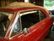 1966 Chevrolet Nova - A red 1966 Chevrolet Nova coupe is seen from the side, partially covered and parked indoors.