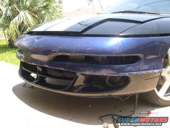 Blue car bumper with racing stripes on hood, showing scratches and damage