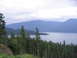 2000 Jeep Cherokee - A vast lake is framed by mountains and dense pine forest under a cloudy sky.