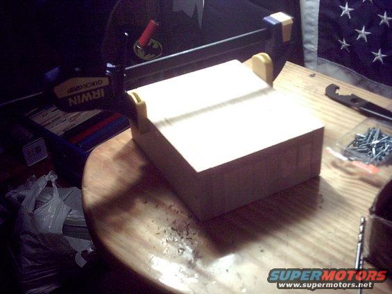 Wooden block on table with clamps and screws