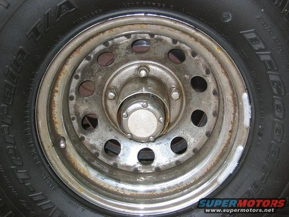 Close-up of a BFGoodrich tire and a weathered wheel with a chrome hubcap