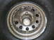 1990 Ford Bronco - A close-up view of a BFGoodrich tire and a weathered wheel, a chrome hubcap with visible lug nuts.