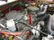 1990 Ford Bronco - Close-up view of a V8 engine bay, showing various hoses, wires, and engine components.