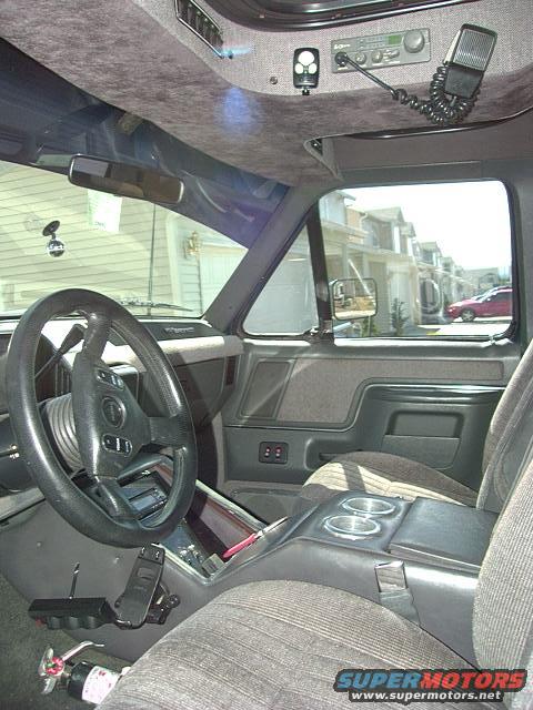 1991 Ford Bronco interior, gray fabric seats, aftermarket radio and microphone, steering wheel, center console with cup holders