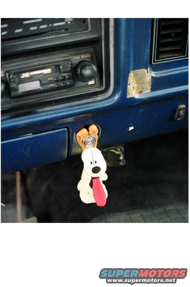 Dashboard interior showing a JVC car radio and a plush dog keychain hanging from the ignition