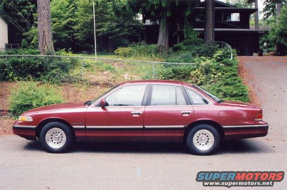 Maroon 1993 Ford Crown Victoria parked on a street in front of a house