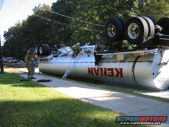 tanker0005.jpg Making an opening to offload what gasoline is left in the tank before righting it.
