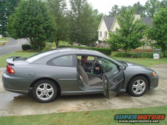 Gray coupe, driver's door open, side view