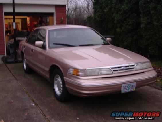 Rose gold 1995 Ford Crown Victoria sedan parked in driveway, front quarter view