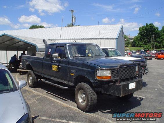 Dark green Ford F-250 pickup with a brush guard and stack exhaust parked outside
