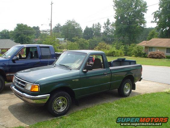 Green Ford Ranger pickup truck, 3/4 front view. Another truck is parked behind it