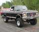 1979 Ford F-250 - Lifted 1979 Ford F-250 pickup truck with patriotic decorations and large off-road tires.