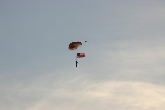 Skydiver descending with an American flag under a parachute