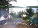 1986 Ford Bronco - Friends enjoy a campfire gathering by the water on a cloudy day.