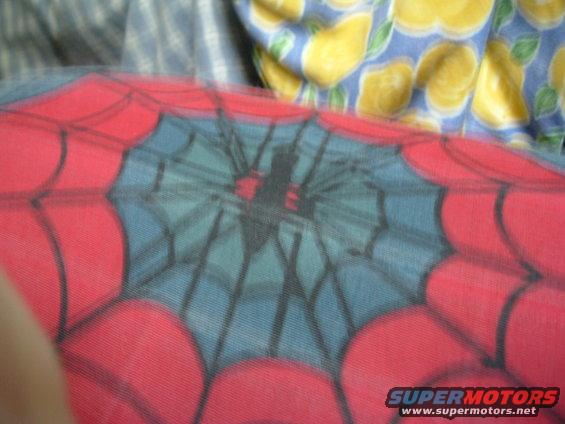 Spider-Man web pattern with a spider silhouette on red and blue fabric, with a lemon-patterned cloth in the background