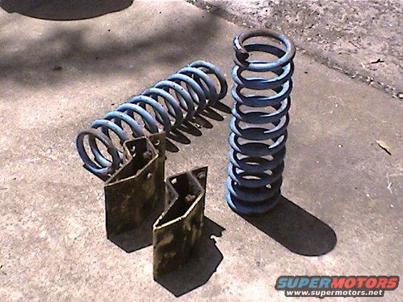 Two blue coil springs and metal brackets on concrete