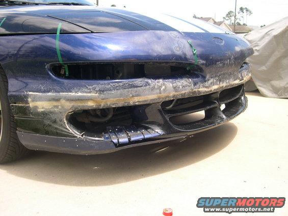 1997 Ford Probe front bumper damaged, showing exposed internal components and tape holding parts
