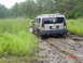 1995 Dodge 1500 - Hummer H2 navigating a muddy trail with tall grass and trees surrounding it.