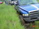 1995 Dodge 1500 - A blue pickup truck is stuck in the mud while other vehicles wait in a grassy field.