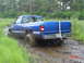 1995 Dodge 1500 - This blue pickup truck, likely from the late 1990s, is struggling to navigate through a muddy terrain.