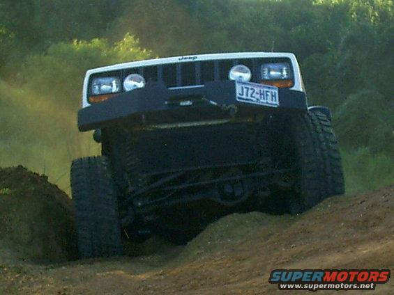 White Jeep Cherokee XJ on dirt track, front view