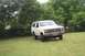 1985 Ford Bronco - This 1980s Ford Bronco is parked on a grassy lawn with trees behind it.