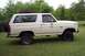 1985 Ford Bronco - Side profile of a white Ford Bronco, showing its classic SUV body style and exterior details.