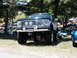 1994 Ford Bronco - A modified Ford Bronco is parked on grass at an outdoor car show with other vehicles in the background.