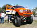 1994 Ford Bronco - Customized pickup truck with extreme lift and off-road tires on display.
