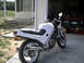 1986 Honda Interceptor - A white Honda motorcycle is parked in a driveway next to a garage. A dark-colored car is visible inside the garage.
