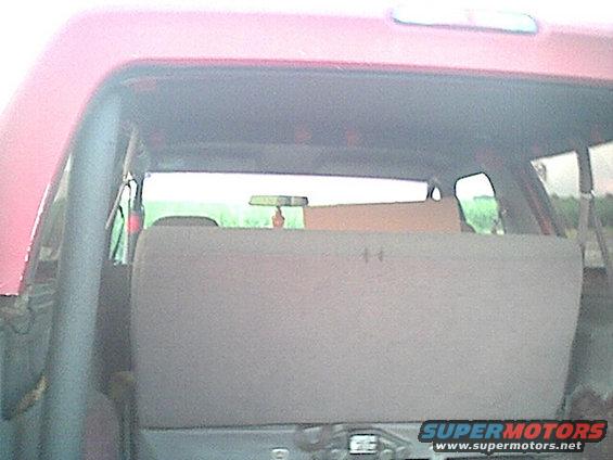 Red SUV interior, rear seats folded down, with a cardboard box on top