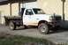 1997 Ford F-350 - This truck has a flatbed with wooden planks and a toolbox mounted behind the cab.