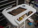 1998 Volkswagen Jetta - A car dashboard trim piece is prepared for painting in a workshop setting.