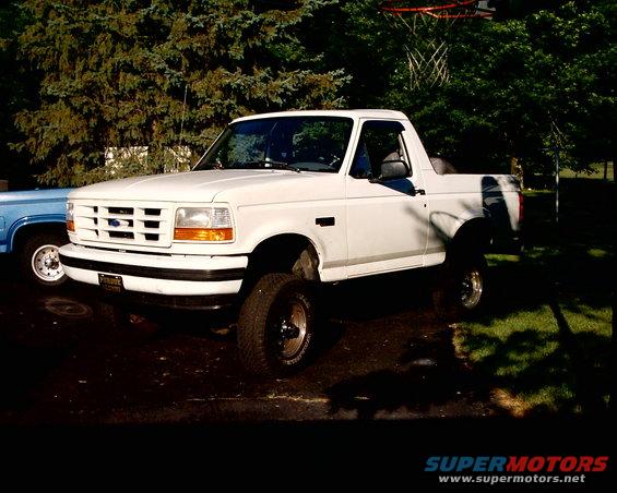 White Ford Bronco, lifted, with aftermarket wheels, parked outdoors