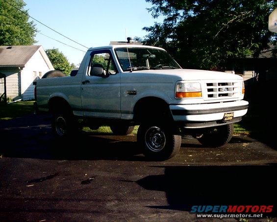 White 1996 Ford Bronco parked on asphalt driveway, front 3/4 view, clear sky