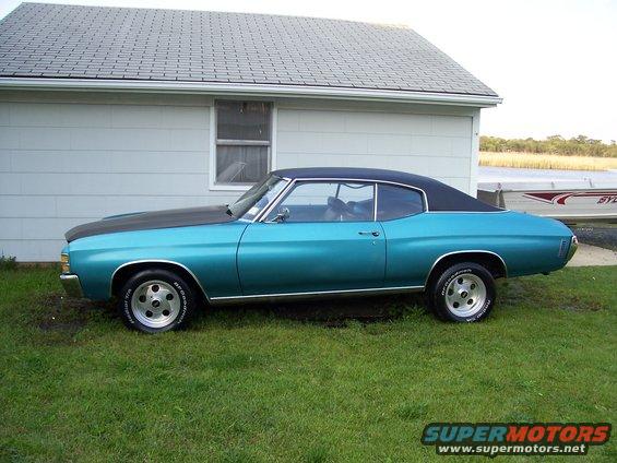 1971 Chevrolet Chevelle coupe with black vinyl roof and hood, parked on grass next to a house