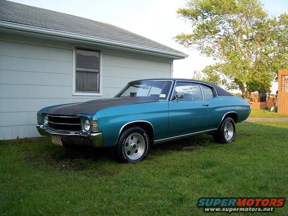 Teal 1971 Chevrolet Chevelle coupe with a black hood and aftermarket wheels parked on grass