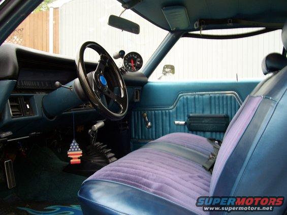 1971 Chevrolet Chevelle interior showing blue door panels, purple velour seat, aftermarket steering wheel, and tachometer
