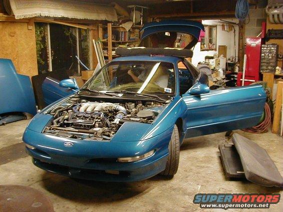 1994 Ford Probe with engine exposed, hood and driver's door open in a garage