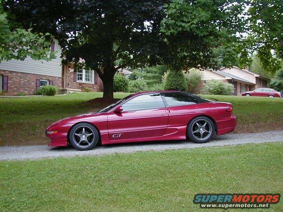 1994 Ford Probe GT parked on gravel drive, with a red sedan in the background