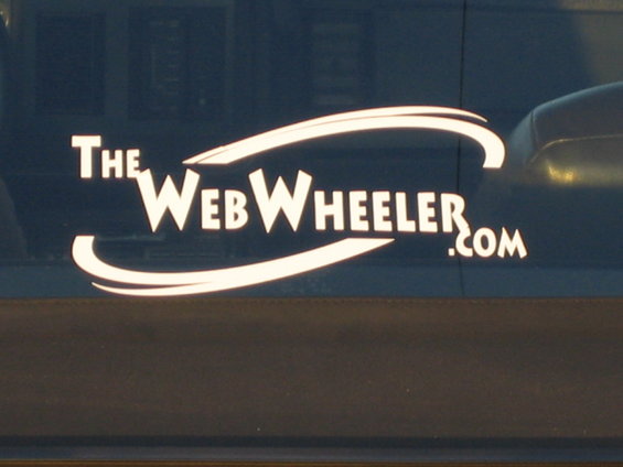 White "The WebWheeler.com" logo on dark blue surface