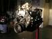 1979 Chevrolet C/K Pickup - Engine assembly displayed on a red stand in a garage setting, with various items in the background.