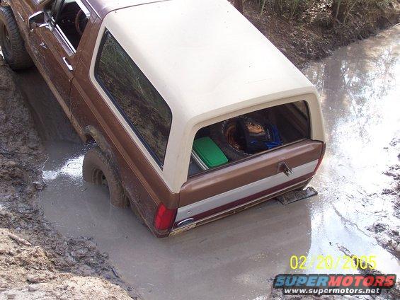 1987 Ford Bronco stuck in a mud pit, rear view