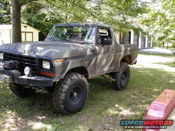 Camouflaged Ford Bronco with large tires and winch