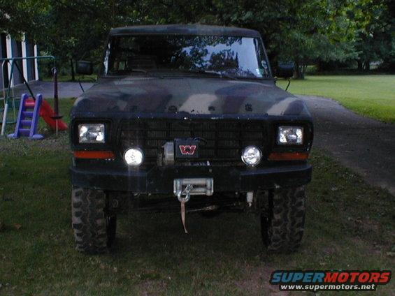 Camouflaged Ford Bronco with a winch and off-road tires, viewed from the front