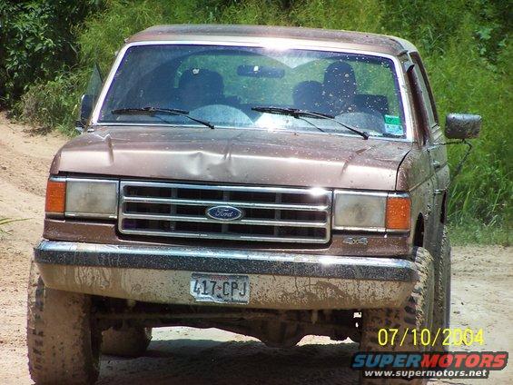 1987 Ford Bronco front view, muddy, with dented hood