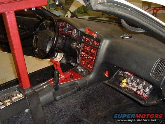 Car interior with digital gauges showing 00 00, 000 000, 000 000, 120 246, and a red roll cage