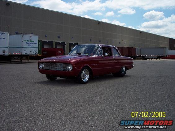 Maroon 1960 Ford Falcon two-door sedan with aftermarket wheels parked on asphalt