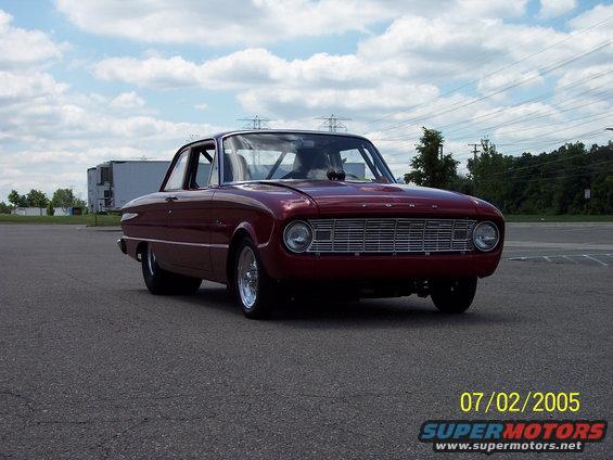 Maroon 1960 Ford Falcon sedan with a chrome grille, parked on asphalt